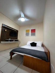 a bedroom with a bed and a ceiling fan at Pérola de Santos House in Santos