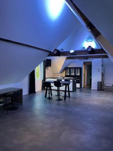 Großes Zimmer mit Tischen und blauem Licht in der Unterkunft Reiger Burg in Ypern