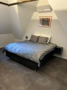 ein Schlafzimmer mit einem großen Bett im Dachgeschoss in der Unterkunft Reiger Burg in Ypern
