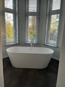 uma banheira branca num quarto com janelas em Reiger Burg em Ypres