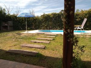 un camino que conduce a una piscina con sombrilla y silla en Casa ROMA, en San Rafael