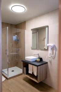 a bathroom with a sink and a shower at La table d’Auguste in Dour