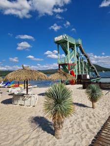 eine Achterbahn am Strand mit Stühlen und Palmen in der Unterkunft Chatky U Davida Máchovo jezero in Doksy