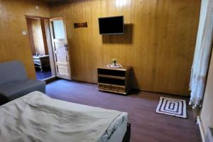 a bedroom with a bed and a tv on the wall at Cabana Cotu lui Iepure in Trăisteni