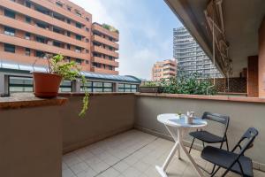 een balkon met een tafel en stoelen in een gebouw bij 4 Star Family & Friends Apt - Self Check-in in Bologna