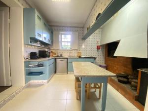 a kitchen with blue cabinets and a table in it at Casa da Ponte in Baião