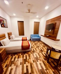 a bedroom with a bed and a tv and a table at Amora Rooms Dwarka in New Delhi