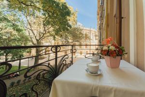 Odessa的住宿－皇家宮殿精品酒店，阳台上的桌子上放着两杯和鲜花