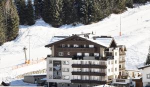 a building on a ski slope with snow at Aktivhotel Feichtner Hof in Kaunertal