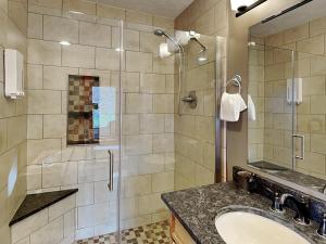 a bathroom with a sink and a glass shower at Our Happy Place in McHenry