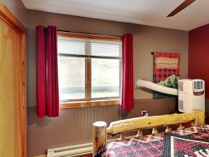a bedroom with a bed and a window with red curtains at Our Happy Place in McHenry