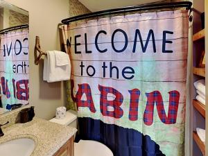 a bathroom with a welcome to the nation shower curtain at Our Happy Place in McHenry +42 photos