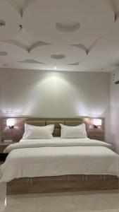 شقق سويت ستار الفندقية في تبوك: غرفة نوم بسرير ابيض كبير مع مخدات بيضاء