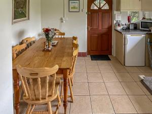 a kitchen with a wooden table and chairs at Edgecoombe in Shaftesbury