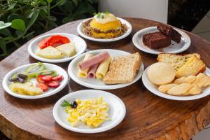 una mesa con platos de diferentes tipos de alimentos en Arrey Rio Poty Praia, en Luís Correia
