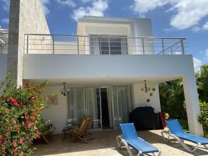 a house with two chairs and a balcony at Villa hermosa en Playa Nueva Romana in San Pedro de Macorís