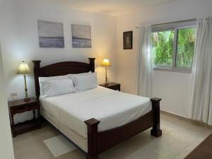 a bedroom with a bed and two lamps and a window at Villa hermosa en Playa Nueva Romana in San Pedro de Macorís