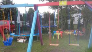 a playground with many different kinds of swings at Domki Żeglarz Ustronie Morskie in Ustronie Morskie