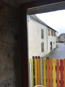 una ventana con vistas a una valla con un edificio en Le grenier en Tauves