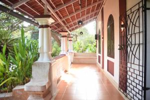 una pasarela exterior de una casa con porche en 4BHK Private Pool villa in North Goa and Kayaking nearby!!, en Moira