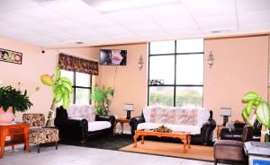a living room with couches and chairs and windows at Florence Inn and Suites in Florence