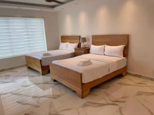 1 dormitorio con 2 camas y ventana en Luxury place playa nueva romana en San Pedro de Macorís
