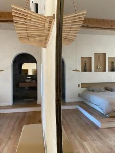 1 dormitorio con 1 cama en una habitación con suelo de madera en Mas Escala Suites & Spa, en Istres