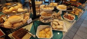un buffet lleno de diferentes tipos de pan y repostería en Hotel LF By Feliciano, en Barracão