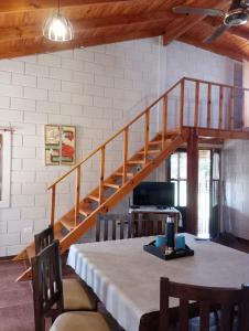 een houten trap in een woonkamer met een tafel bij Cabaña La Rosita in Villa Quillinzo