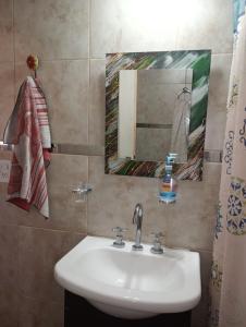 een badkamer met een wastafel en een spiegel bij Cabaña La Rosita in Villa Quillinzo