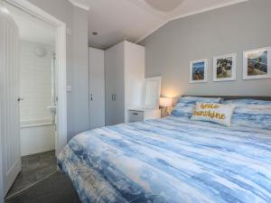 a bedroom with a large bed with a blue comforter at Lake View Lodge in Tallington