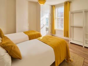 2 camas en una habitación con cortinas amarillas en Host & Stay - Grosvenor House en Margate