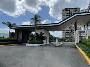 un edificio con una palmera en un aparcamiento en Nuevo Apto in Juan Dolio en Guayacanes