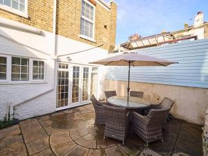 una mesa con sombrilla en el patio en Host & Stay - Grosvenor House en Margate