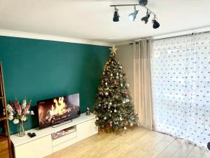 einen Weihnachtsbaum in einem Wohnzimmer mit einem TV in der Unterkunft Heart of Windsor in Windsor