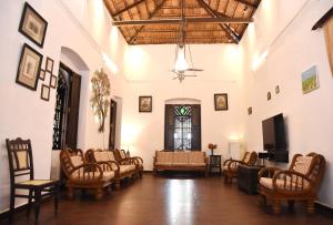 a living room with a bunch of chairs and a tv at 4BHK Private Pool villa in North Goa and Kayaking nearby!! in Moira