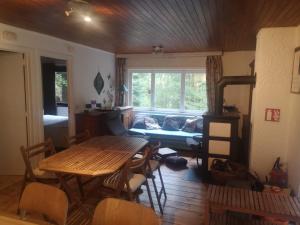 - un salon avec une table en bois et un canapé dans l'établissement Chalet - Au retour vers Soi, à Les Nobertins