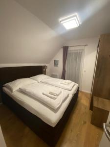 a bedroom with a bed with two towels on it at Lipno Village House in Frymburk