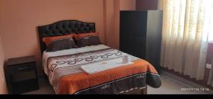 Un dormitorio con una cama grande y una bandeja. en HOSTAL LLAUT * *, en Moquegua