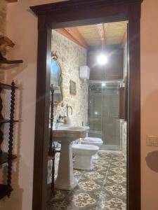 a bathroom with a sink and a toilet and a shower at Casa tipica sarda in Gonnosnò