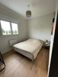 1 dormitorio pequeño con 1 cama y 2 ventanas en Les Chalets du Mancel - Chalet Tennessee - 500 m Bouleries Jump , 10 min du circuit des 24h, en Parence