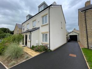 a white house with a driveway at Sophisticated & Contemporary Modern House for 6 Pass the Keys in Chapel en le Frith