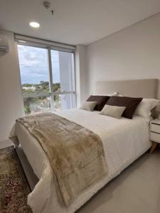 a bedroom with a large bed with a large window at Edificio IN 1362 MOLAS in Asuncion