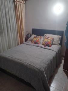 um quarto com uma cama com duas almofadas em cálida, acogedora habitación cerca a Unicentro de occidente em Bogotá