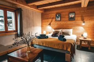 ein Schlafzimmer mit einem Bett in einem Blockhaus in der Unterkunft Le Chalet de Vincent in Cordon
