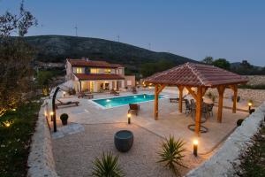 a backyard with a swimming pool and a gazebo at Villa Natura Piedra in Slivno