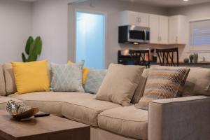 sala de estar con sofá marrón con almohadas amarillas en Luxurious Home With Hot Tub & Tree Deck By 6flags, en San Antonio