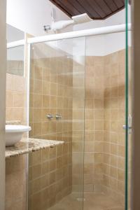 een glazen douche in een badkamer met een wastafel bij Concha Tropical Flat in Itacaré