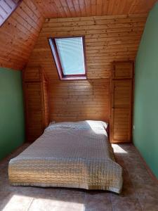 1 dormitorio con 1 cama en una habitación con ventana en Saci Lak, en Gyenesdiás