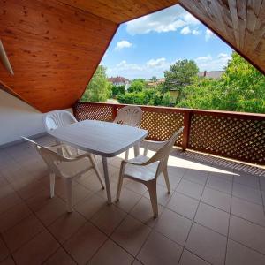 een witte tafel en stoelen op een balkon bij Saci Lak in Gyenesdiás